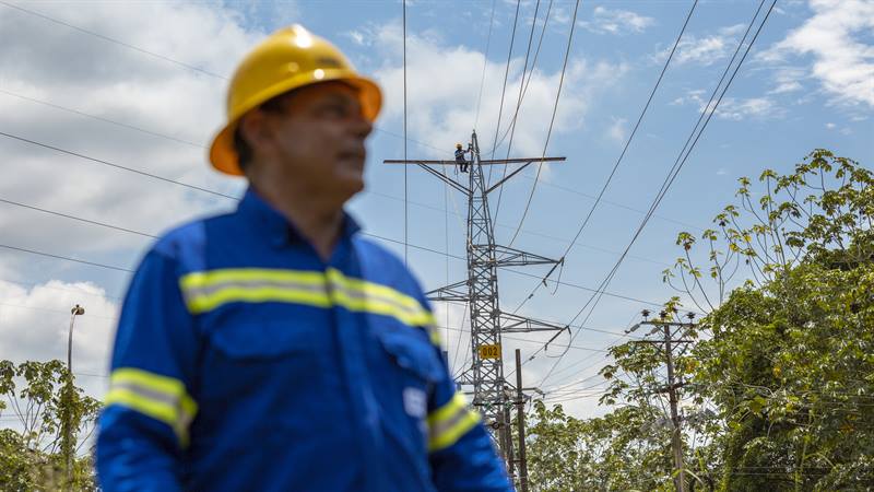 Hombre trabajador ESSA, delante de una torre de energía