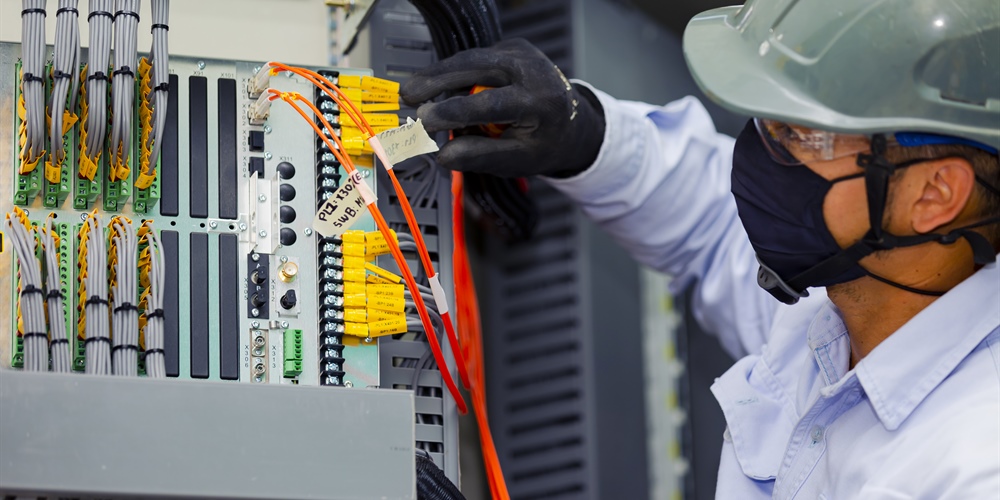Hombre realizando mantenimiento a un equipo eléctrico