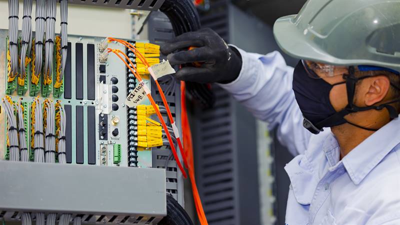 Hombre realizando mantenimiento a un equipo eléctrico