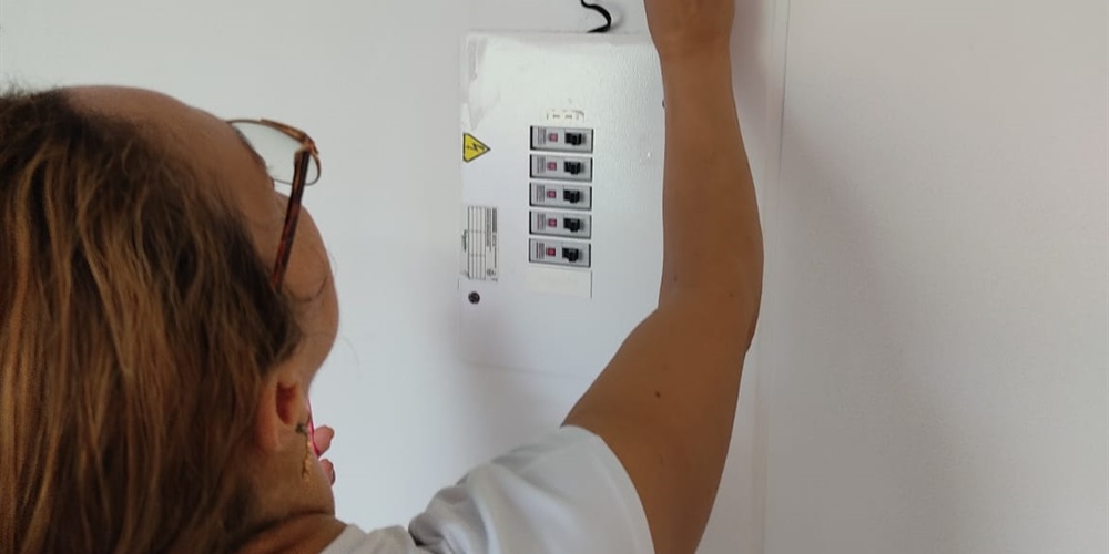Imagen de mujer realizando la recarga de energía prepago, en su medidor.