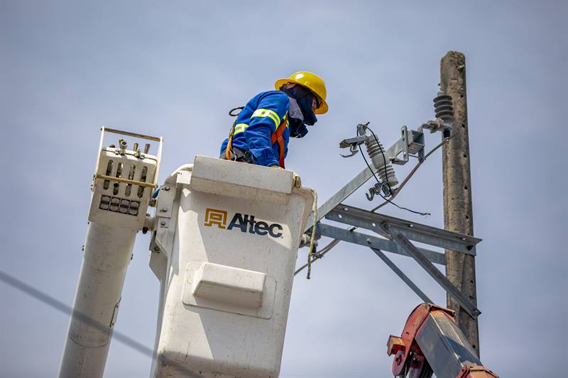 Una persona con casco, trabajando en una red de energía