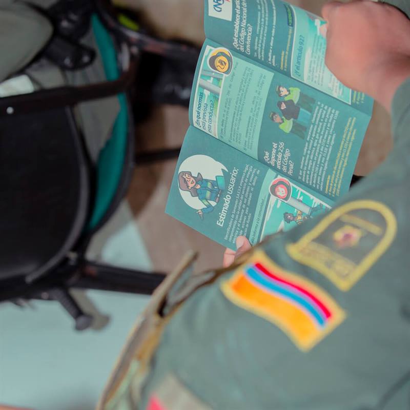 Fotografía persona verificando folleto Normatividad Hogar