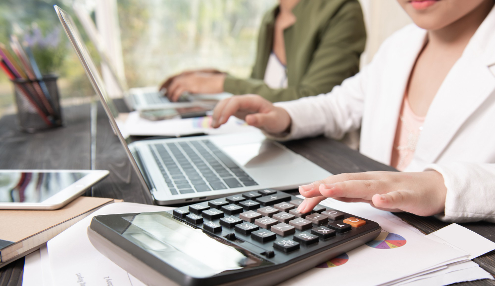 imagen de referencia mujeres con computadores portátiles, documentos y una calculadora imagen de referencia mujeres con computadores portátiles, documentos y una calculadora